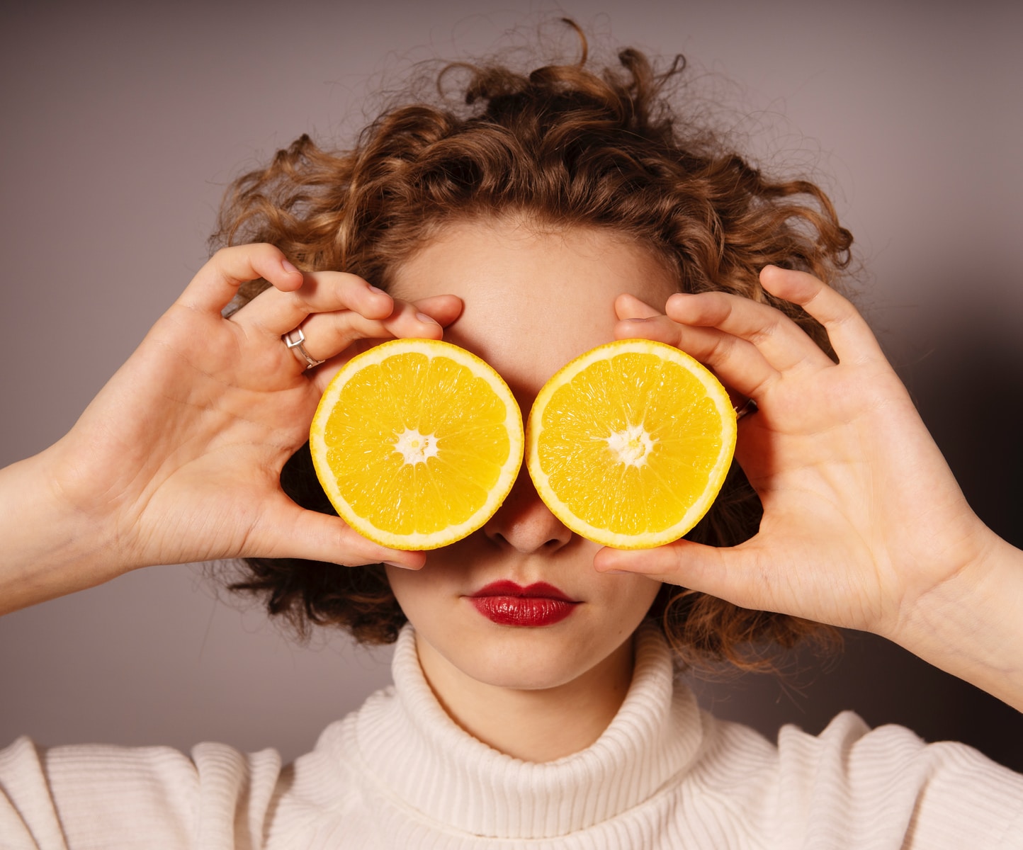 woman holding sliced orange fruit