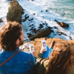 woman in blue denim jacket holding white smartphone