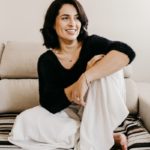 woman in black long sleeve shirt sitting on white couch